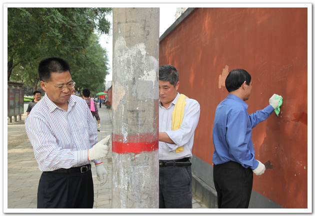 市建委会计师赵建民正在清除电线杆上的小广告