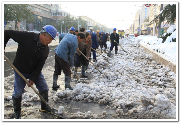 特级建筑企业的工人正在清扫中原路上的积雪