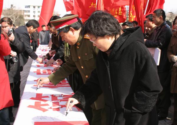市领导和群众一道在写有“创建国家卫生城市，构筑健康和谐郑州”的大型宣传条幅上签字