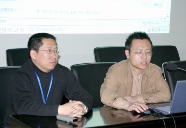 薛洪杰（右）和张涛（左）向各个建筑业企业讲解电子档案的录入并对企业提出的问题做一一解答