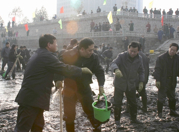 市建委的同志们充分发挥团队精神，十多个人排成一条“流水线”，用塑料桶抬起淤泥，逐个往外传递
