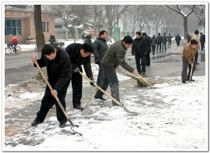 我委组织职工清扫道路积雪方便市民出行