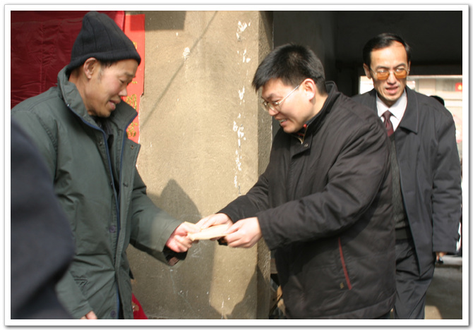 市建委总经济师闫建民亲自把慰问金送到贫困户的手中